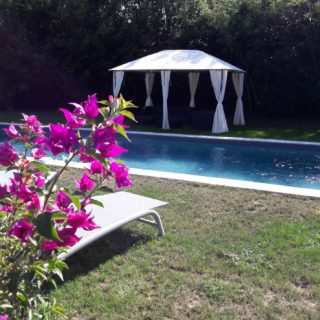 Beautiful and large swimming pool with deckchairs and garden lounge to relax under the shade of the arbor