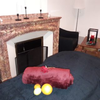 Nicely decorated massage table in a lounge with fireplace