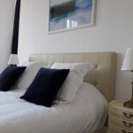 Suite Water with refined decoration, soft pillows, a beige padded headboard and a water-themed photo frame