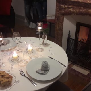 Nicely dressed table by the fireplace for a romantic dinner